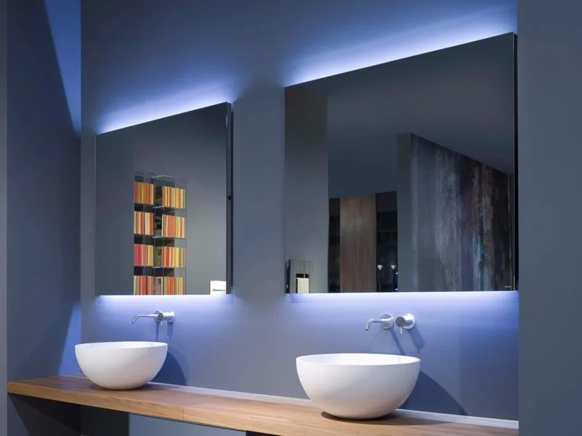 baño con dos senos bajo encimera de lavabo , dos grifos en castrados ,espejos led azules 