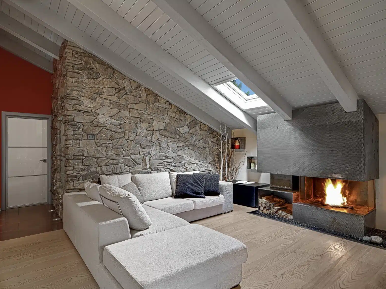ático techo de madera blanca y pared de piedra con chimenea