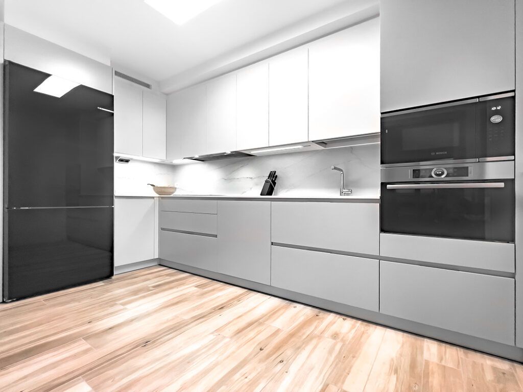 cocina con muebles grises parte de abajo y muebles blancos ariba