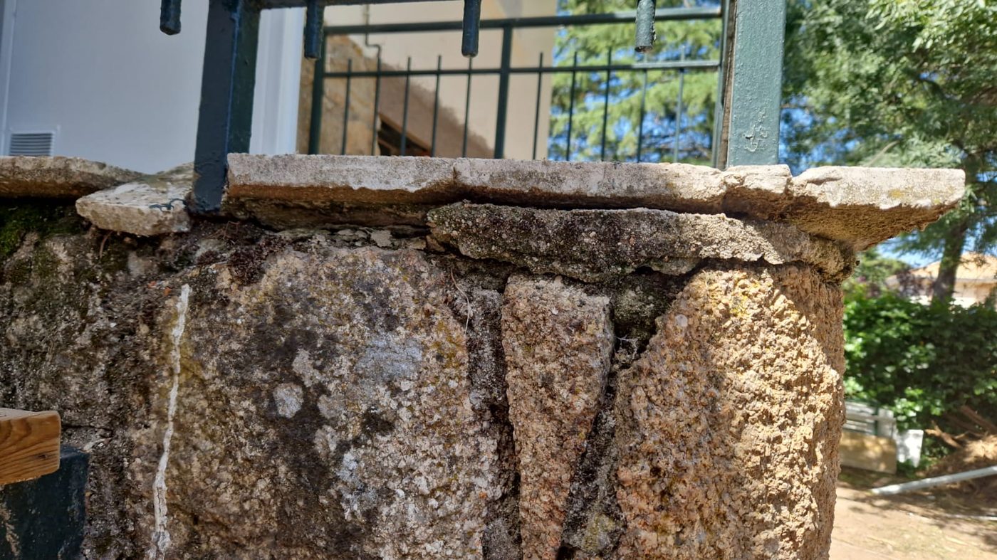 Albardilla de piedra deteriorada sobre el muro de mampostería antes de la reforma exterior