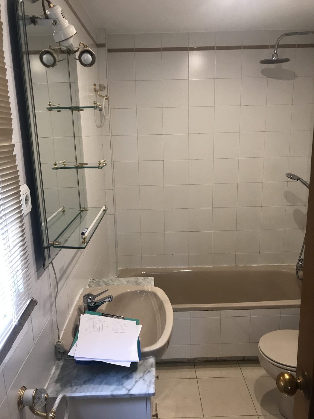 Baño antes de la reforma en Mataelpino: bañera beige, grifería dorada y alicatado antiguo