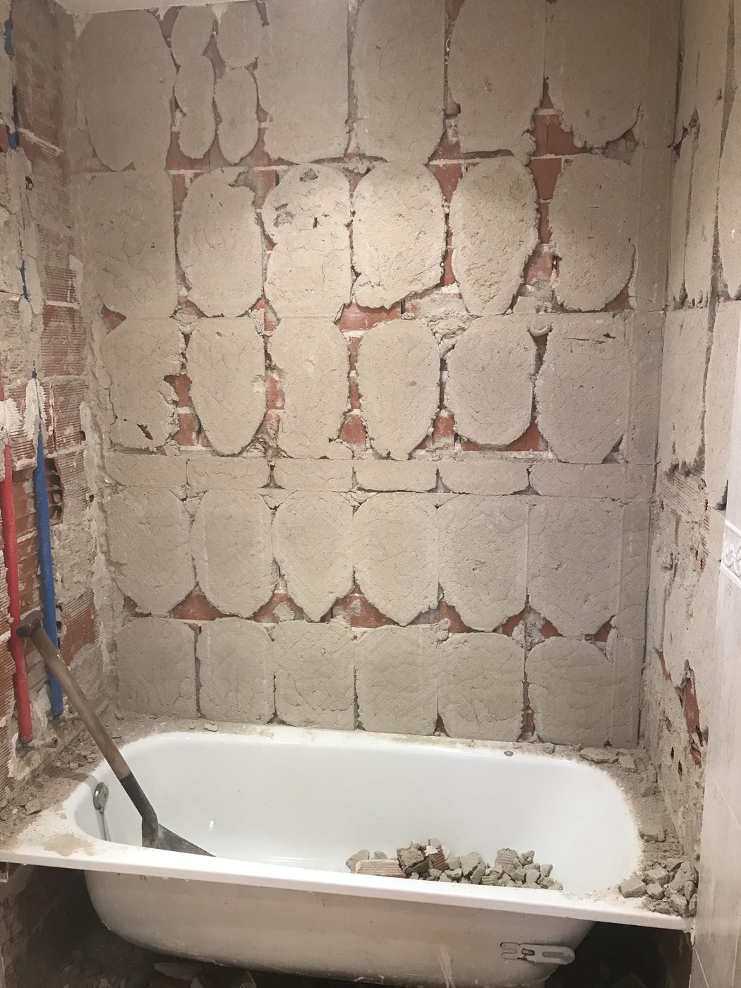 Demolición del alicatado del baño en Mataelpino con la bañera aún instalada