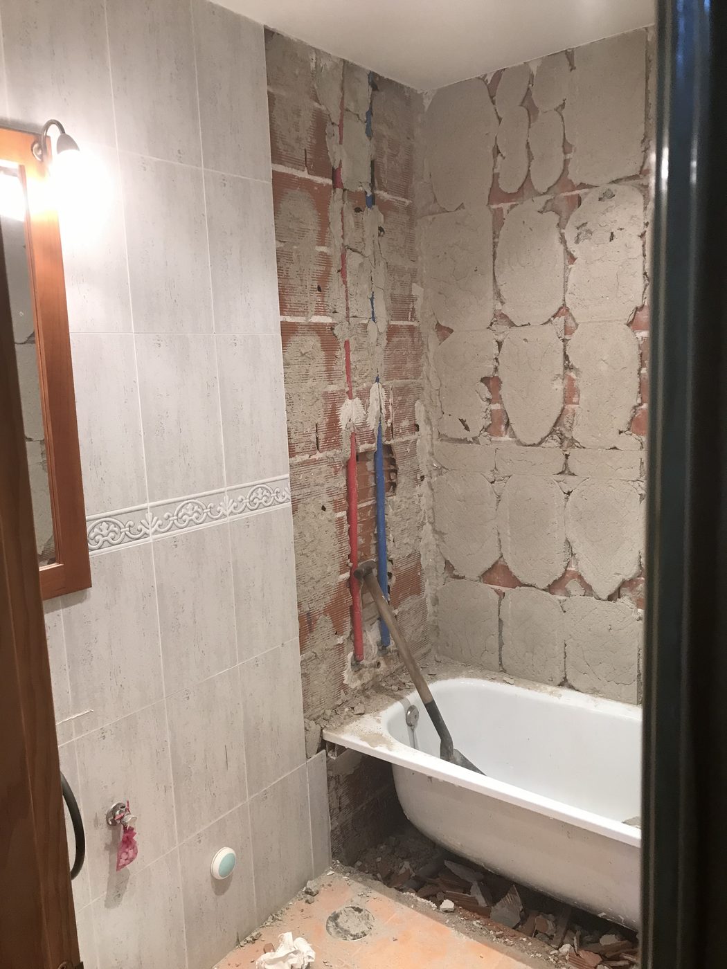 Tuberías multicapa nuevas, roja y azul, empotradas en la pared de la ducha