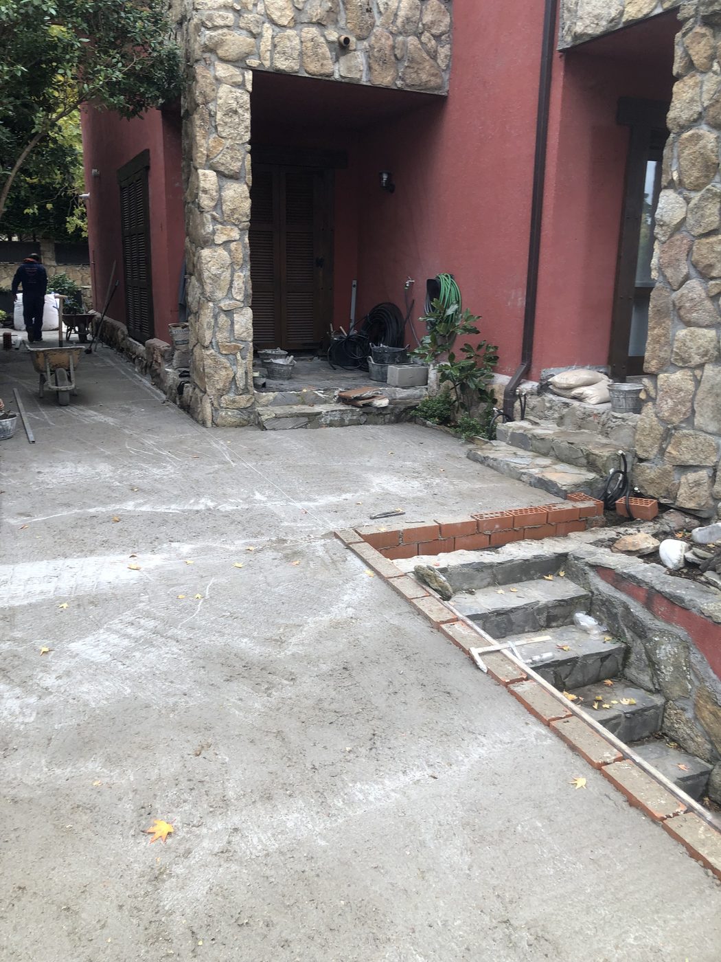 Jardineras de ladrillo y escalera de piedra durante la obra exterior