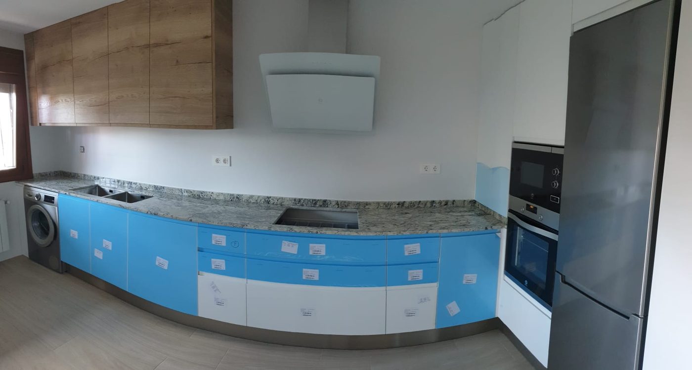 Montaje de la cocina: muebles con film protector azul y encimera de piedra natural