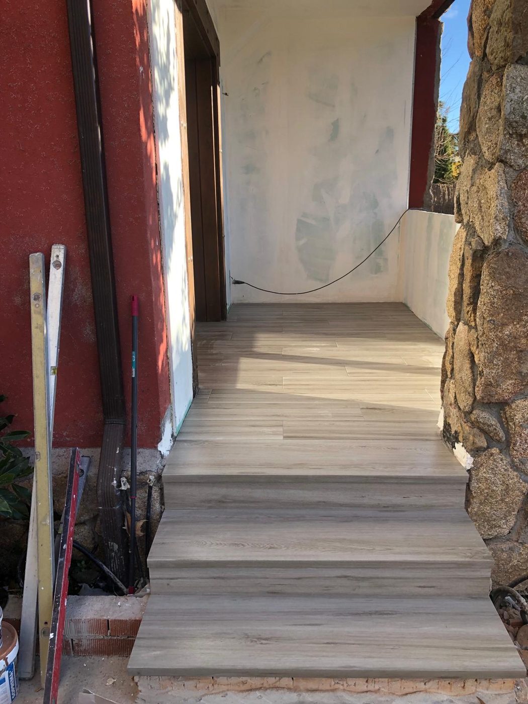 Porche y escaleras terminadas en porcelánico imitación madera